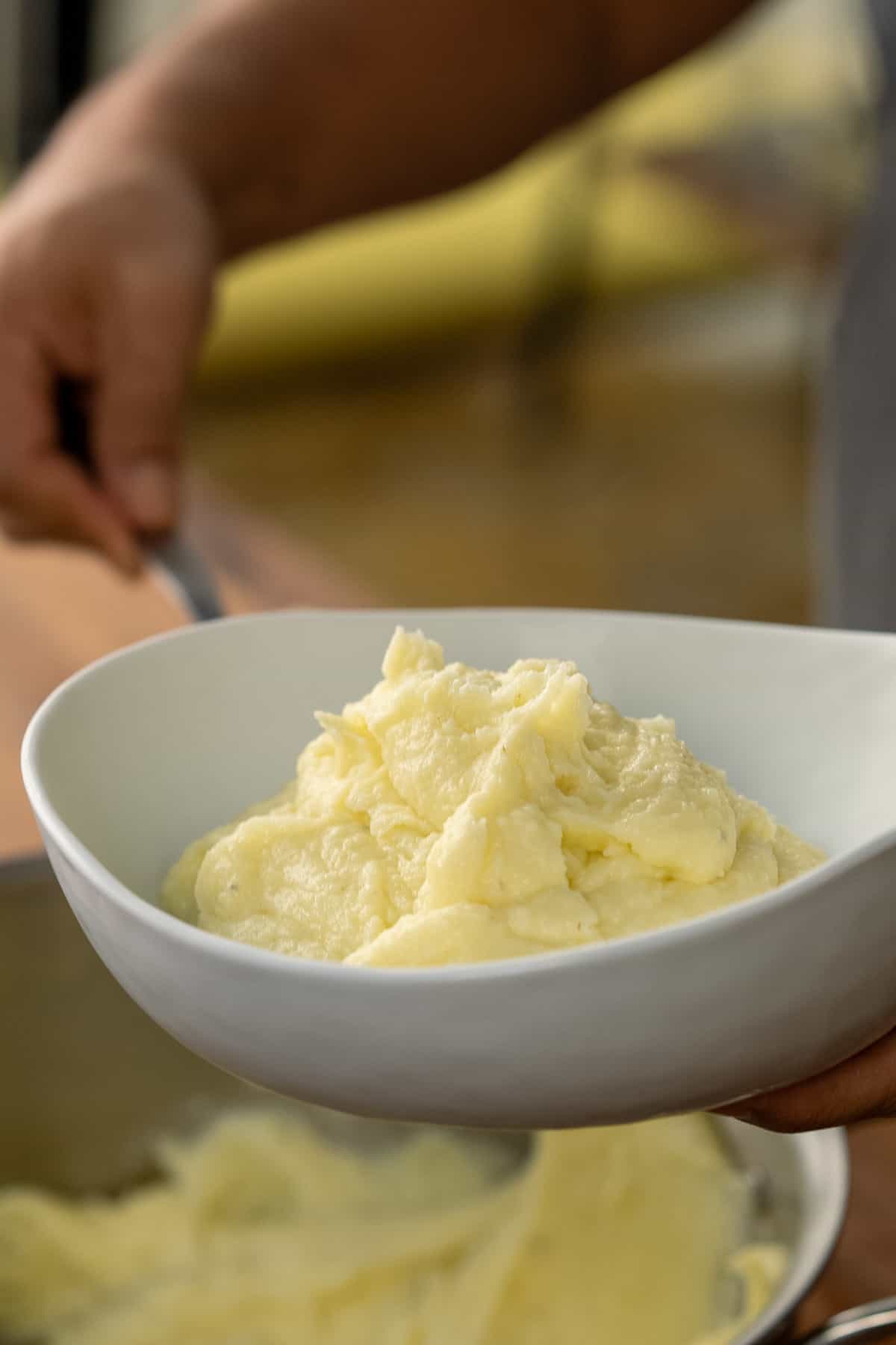 Plating mashed potatoes into a bowl