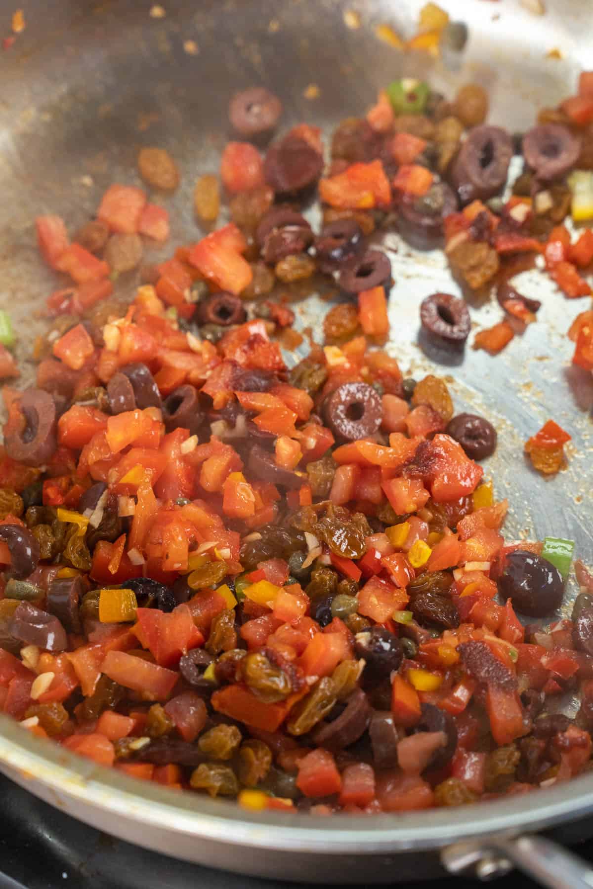 tomatoes, garlic, kalamata olives, and capers sautéing. 